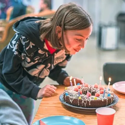 Une enfant souffle les bougies de son gâteau